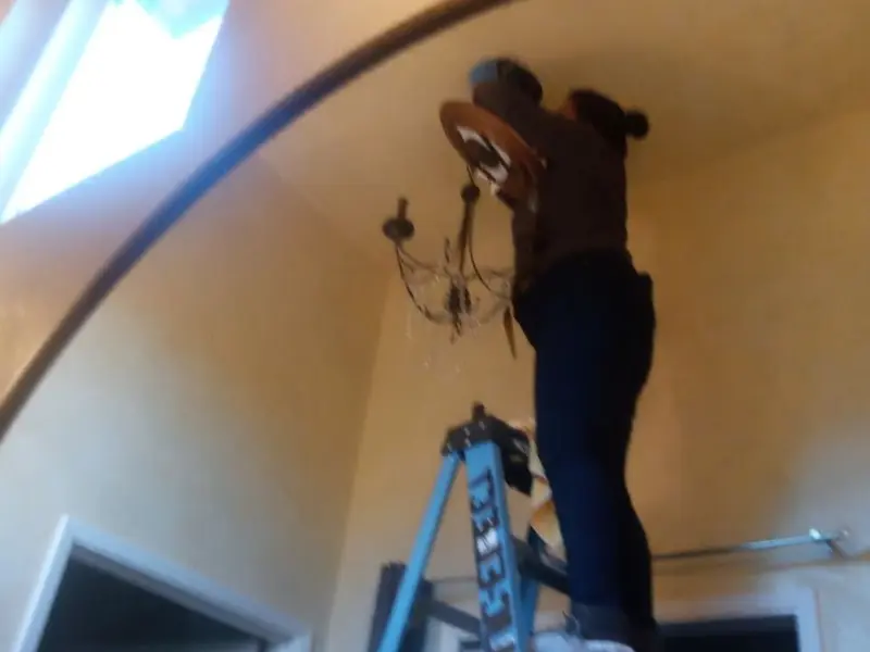Electrician installing a chandelier in a Mount Vernon residence